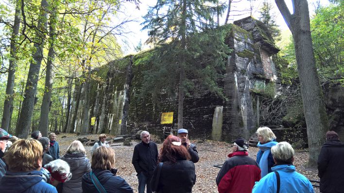 Reisegruppe an der Ruine von Hitlers Bunker in der Wolfsschanze