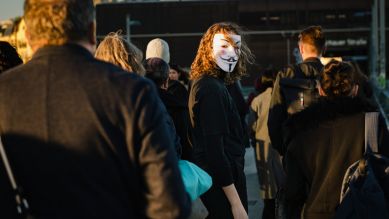Person mit Maske zwischen Passanten auf Bürgersteig, Podcast "Legion: Hacking Anonymous" (Bild: rbb/Jacobia Dahm)