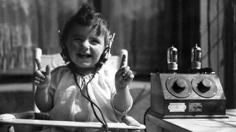 Die Anfänge der Radioübertragung - ein Kind mit Kopfhörern am Radio, 1925 (Quelle: rbb/Ullstein Bild)