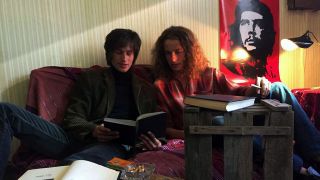 Filmszene: Kapital, zwei junge Männer lesen auf einer Couch, Che Guevara-Poster an der Wand, Quelle: rbb
