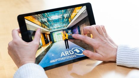 Promobild Besuchertour durch das ARD-Hauptstadtstudio. Zwei Hände halten Tablet. (ARD/CHRISTOPHER DOMAKIS)